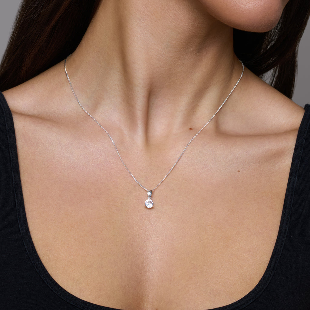 Silver necklace with a teardrop-shaped pendant on a white background