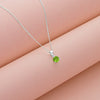 Green gemstone necklace on a pink surface