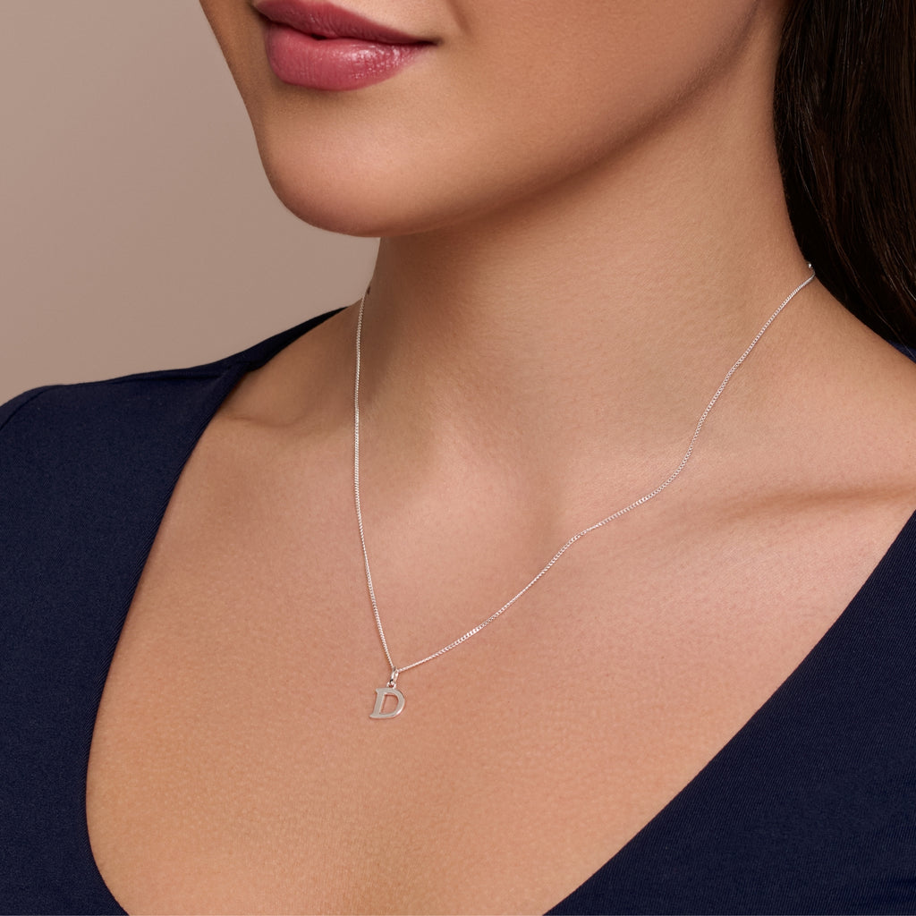 A sterling silver necklace with an engraved letter 'D' on a chain.
