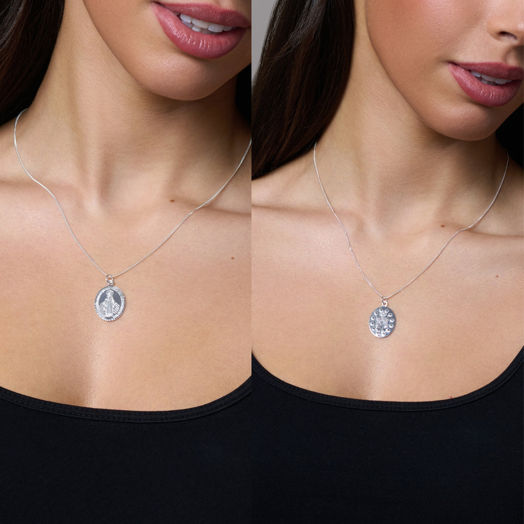 Two silver religious pendants on chains against a white background