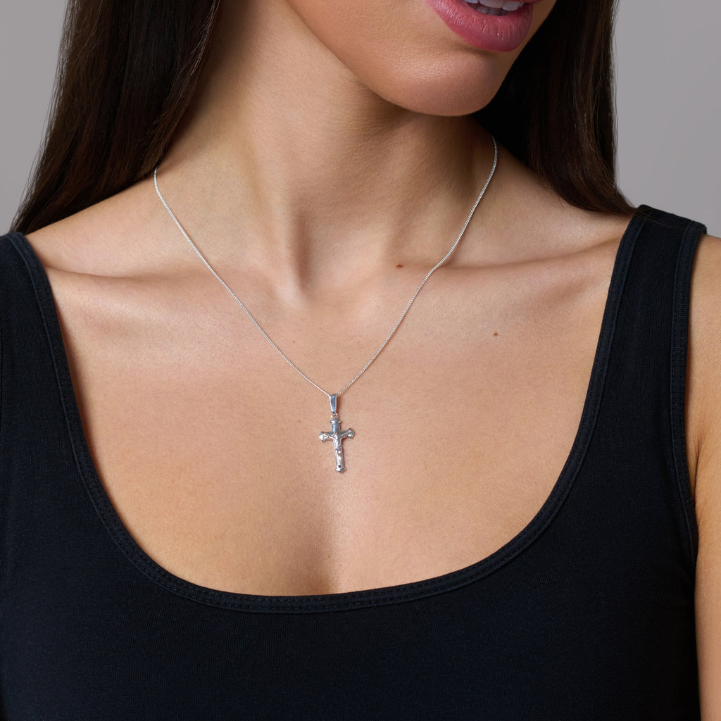 A sterling silver cross pendant necklace with a chain.
