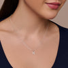 Silver necklace with a 'K' pendant on a model wearing a dark blue top.