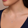 Silver necklace with a pendant on a person wearing a dark blue top.