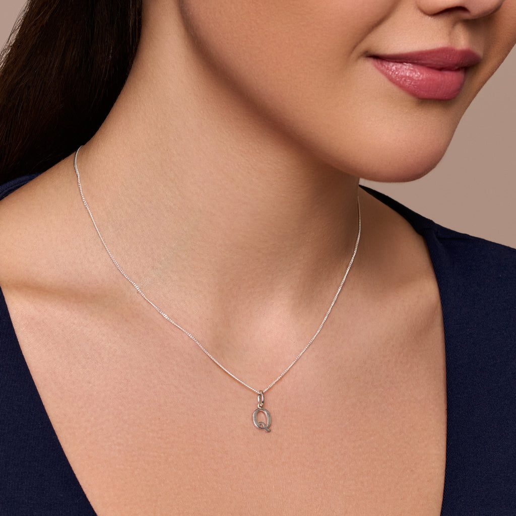 A sterling silver necklace with a Q-shaped pendant, part of an adjustable chain.